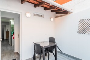 Cozy dining area with a small table and two chairs, set against a white wall.