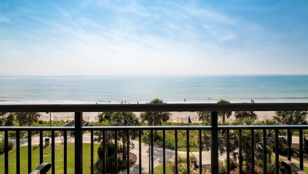 Un balcone con vista sulla spiaggia e sull'oceano.