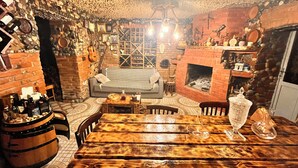 A cozy room with a brick fireplace, a sofa, and a wooden table with bottles.