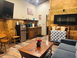 Cozy living room with a wooden floor, coffee table, and flat-screen TV.