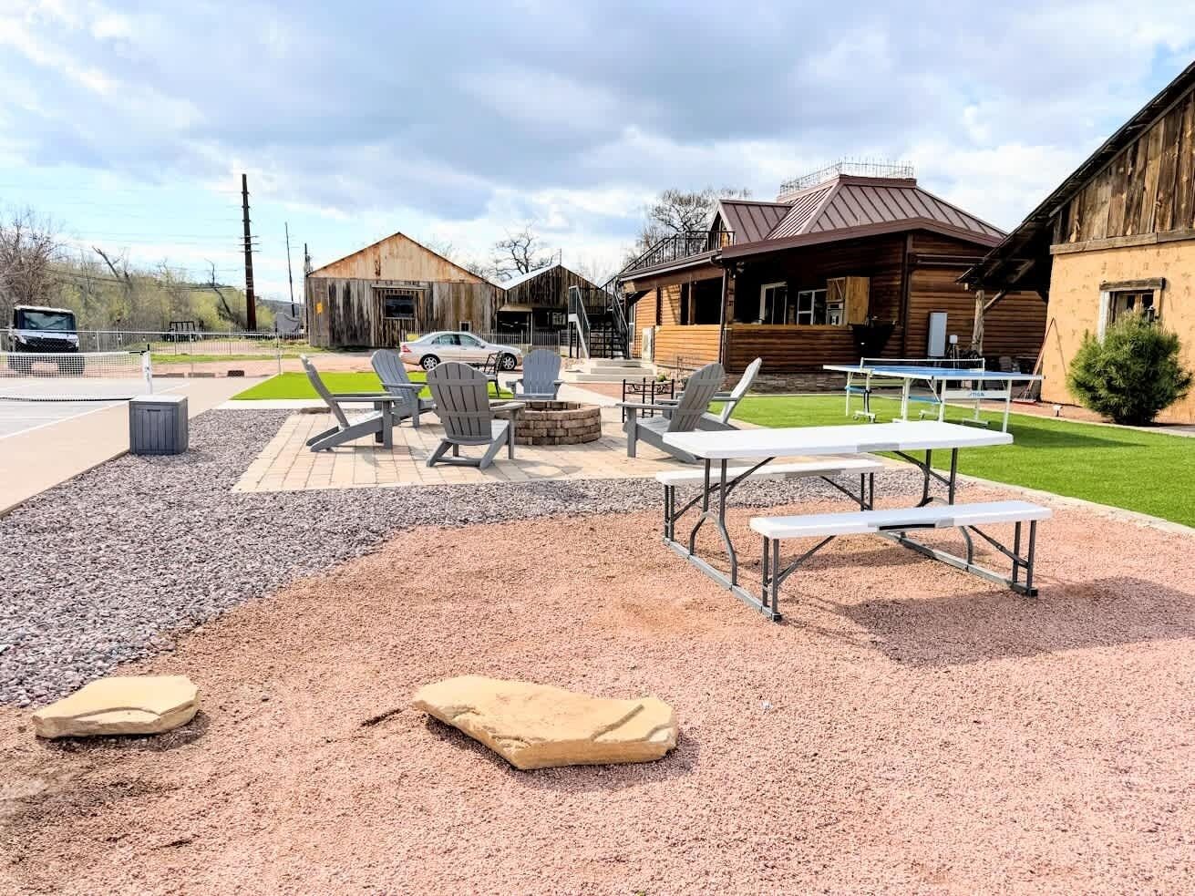 Un espace extérieur aménagé avec un coin salon, un foyer et un sol en gravier.