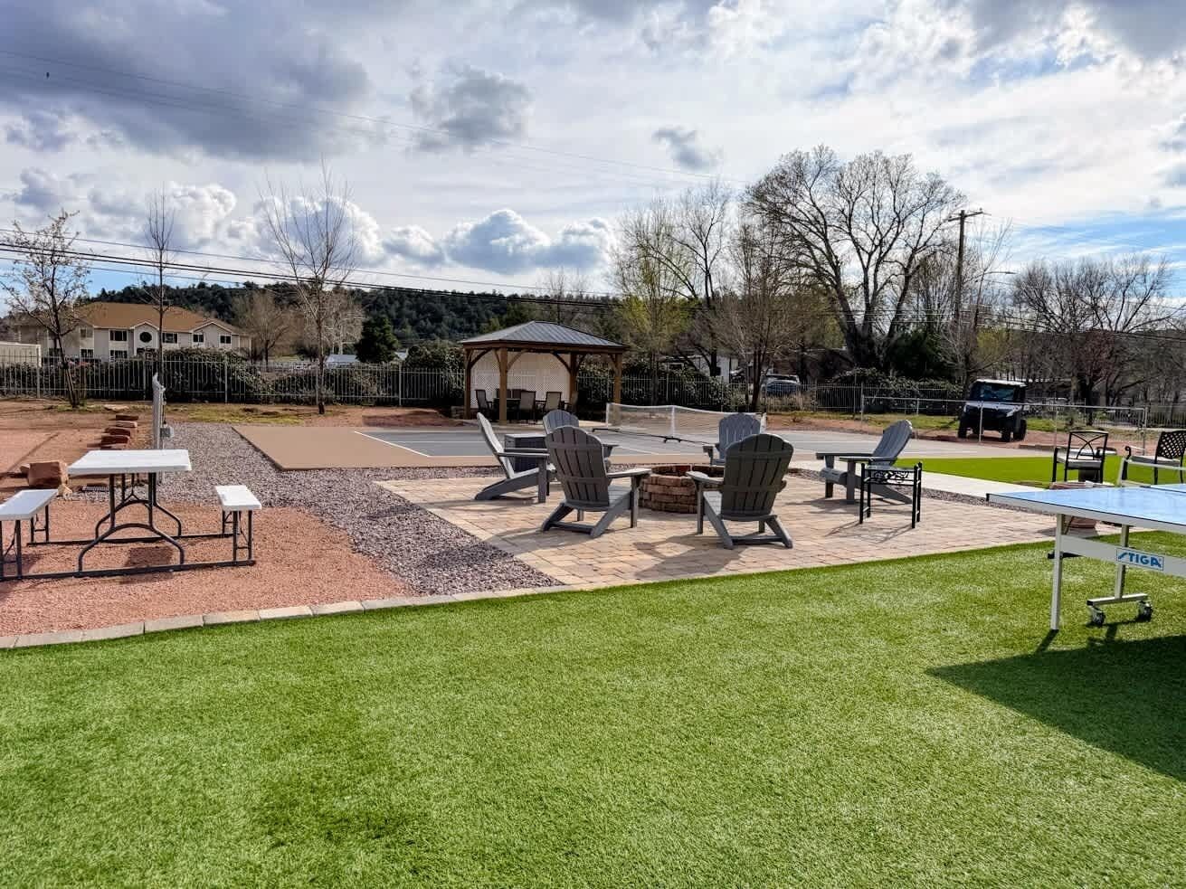 Un patio con mobiliario exterior, una mesa de ping pong y una zona de estar techada.