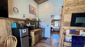 A rustic kitchen with wooden floors, a refrigerator, microwave, and a sink. - Adventure Cabin within the Heart of Arizona! Pickle ball court! (Payson)