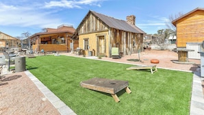 Un bâtiment rustique en bois, doté d’un porche, d’une petite pelouse et de sièges installés à l’extérieur.
