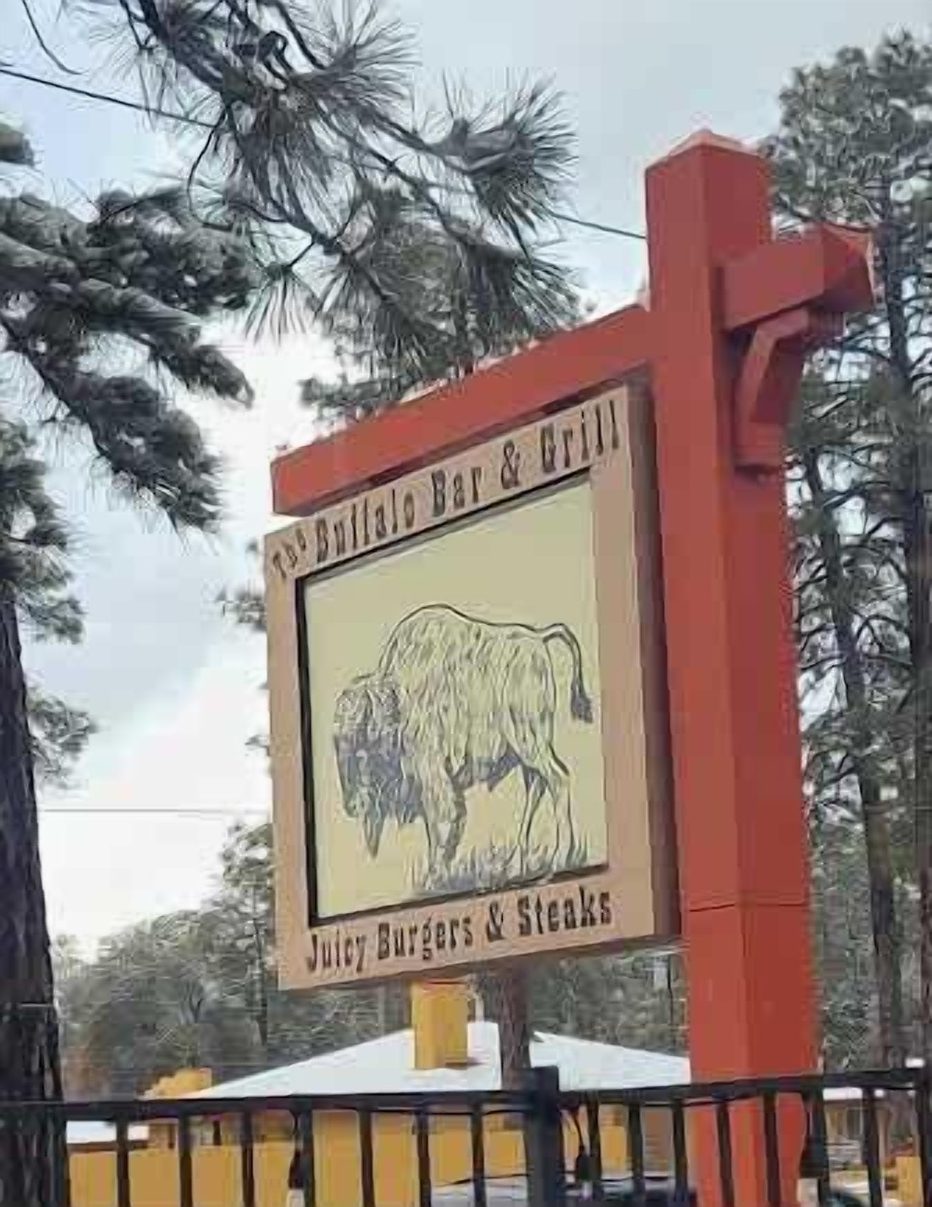 A sign for Buffalo Bar & Grill advertising juicy burgers and steaks.
