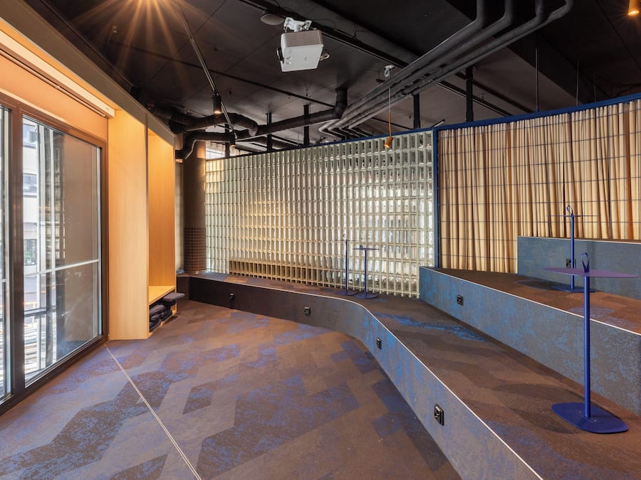 A modern interior with large windows, a seating area, and a counter.