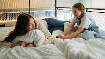 Makuuhuone, jossa on kerrossänky, verkkomainen pääty ja yöpöytälamppu.