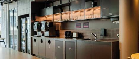 Una cocina moderna con una estación de café, un lavamanos y una vitrina de vidrio.