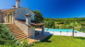 A stone house with a swimming pool, surrounded by lush greenery and a clear blue sky. - Cozy home in Rakotule (Rakotule)