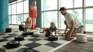 Un vaste espace intérieur doté de grandes fenêtres, d’un sol à carreaux et d’équipements de musculation.