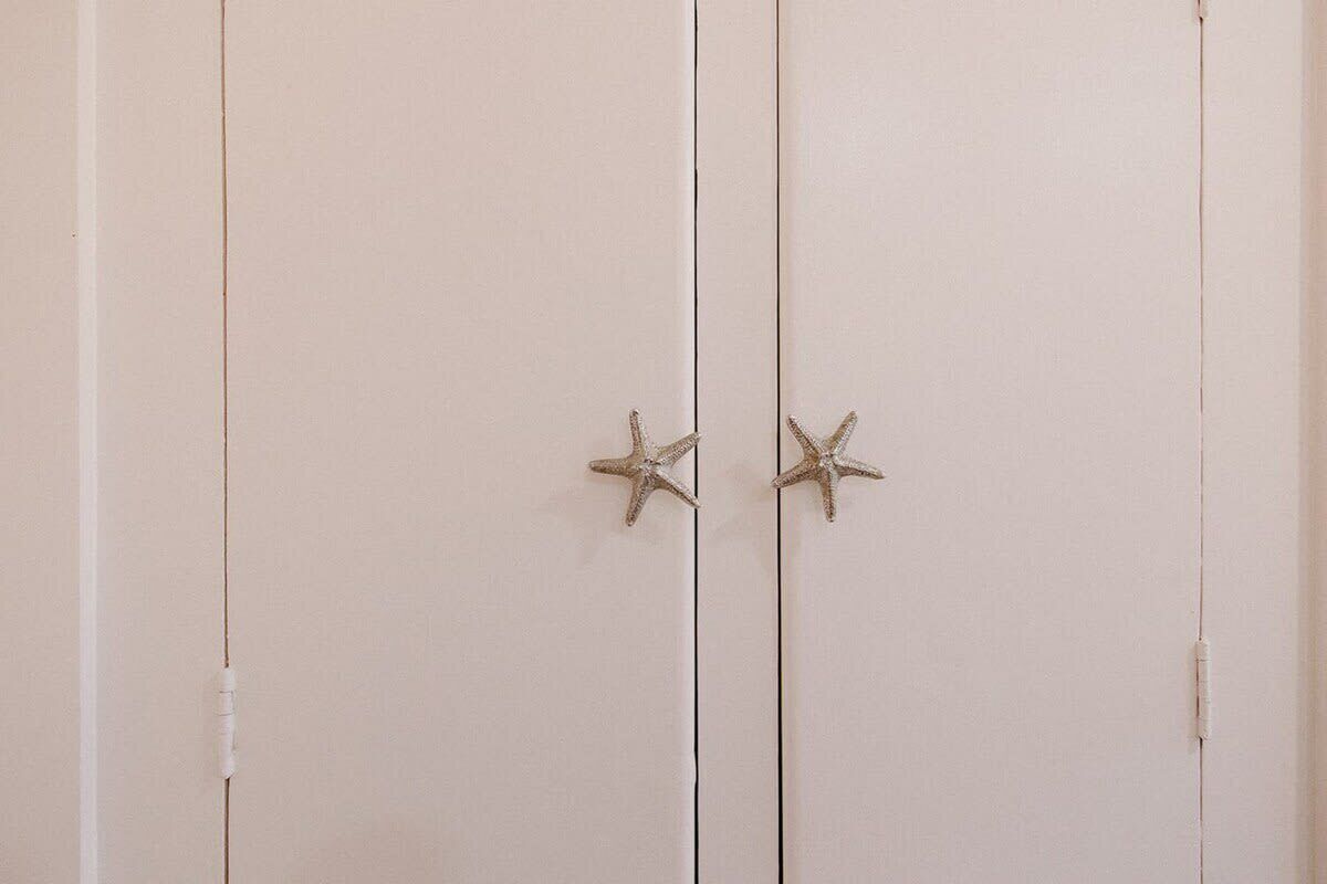 A white wardrobe with two starfish-shaped handles.
