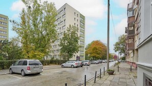 A residential street with parked cars, apartment buildings, and trees. - Stylish Studio in the Center | 15 minutes to the Market Square of Wroclaw (Wroclaw)