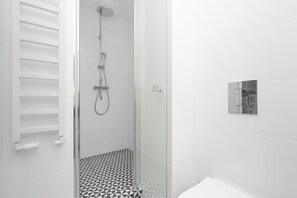 Un baño moderno con ducha, inodoro y lavamanos.