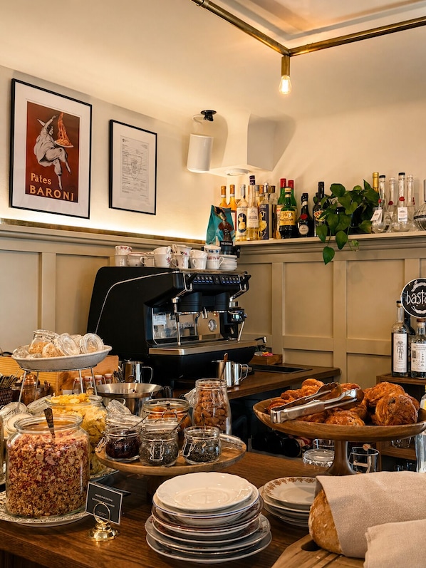 A buffet setup with various food items, a coffee machine, and a bar area with liquor bottles.