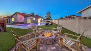 A backyard with a swimming pool, a fire pit, and outdoor seating. - Single Story 3BR w/ Pool, Hot Tub, Firepit & Grill (Henderson)