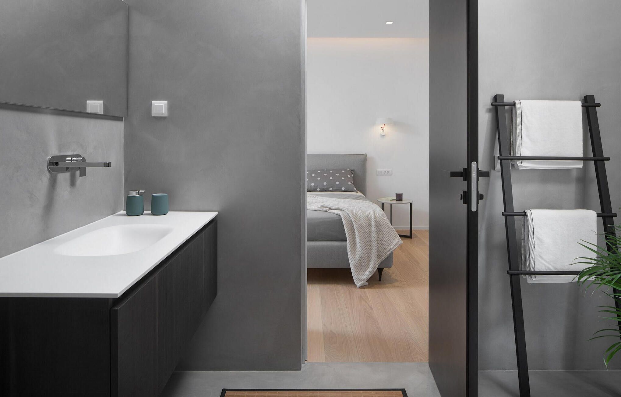 A modern bathroom with a large sink, dark cabinetry, and a towel rack.