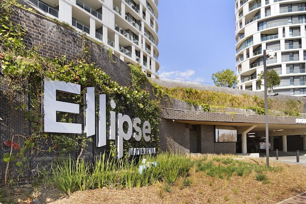 A modern building with a prominent 'Ellipse' sign, surrounded by greenery and a parking area. - Ellipse Waterfall 31002 (Midrand)