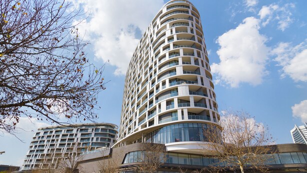 Un moderno edificio de gran altura con múltiples balcones y ventanas amplias.