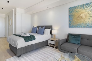 Una camera da letto moderna con un letto, un comodino e una poltrona.
