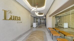 Un interior modern amb una taquilla d'eixida, seients i un cartell que diu "The Luna Club".