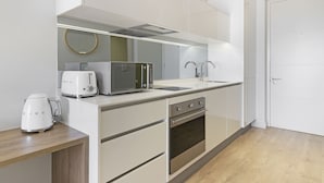 Una cuina moderna amb microones, torradora, bullidor i forn.