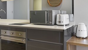A modern kitchen with a stainless steel microwave, toaster, and coffee maker on the countertop.