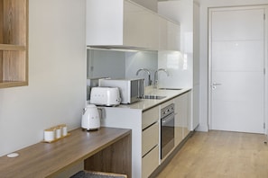 Een moderne keuken met witte apparaten, een houten aanrecht en een ingebouwde oven.