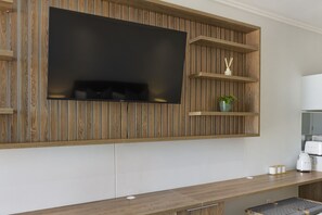 A modern kitchen with a built-in TV, wooden paneling, and a countertop with a kettle and cups. - Ellipse Waterfall 3802 (Midrand)