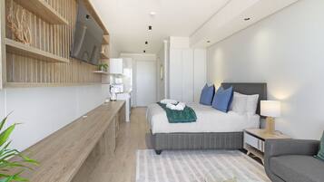 Un dormitorio moderno con una cama, mesitas de noche, un sofá y un banco de madera.