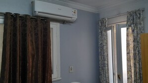Une salle de bain avec un climatiseur blanc, une fenêtre à cadre blanc et une porte en bois.