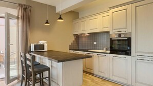 A kitchen with a central island, white cabinets, a Bosch oven, and a microwave. - Stunning home in Porec (Porec)