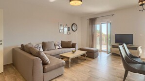 A modern living room with a sofa, coffee table, and a TV. - Stunning home in Porec (Porec)