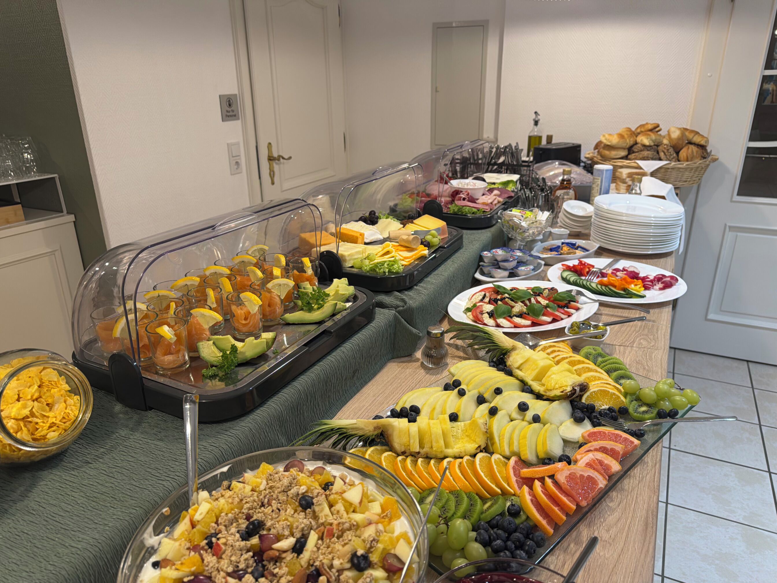 A buffet with various food items including fruits, salads, and beverages.