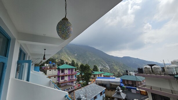 A view of a mountainous landscape with buildings in the foreground. - LA SIESTA INDIA HOSTEL Mcleodganj (Dharamshala)