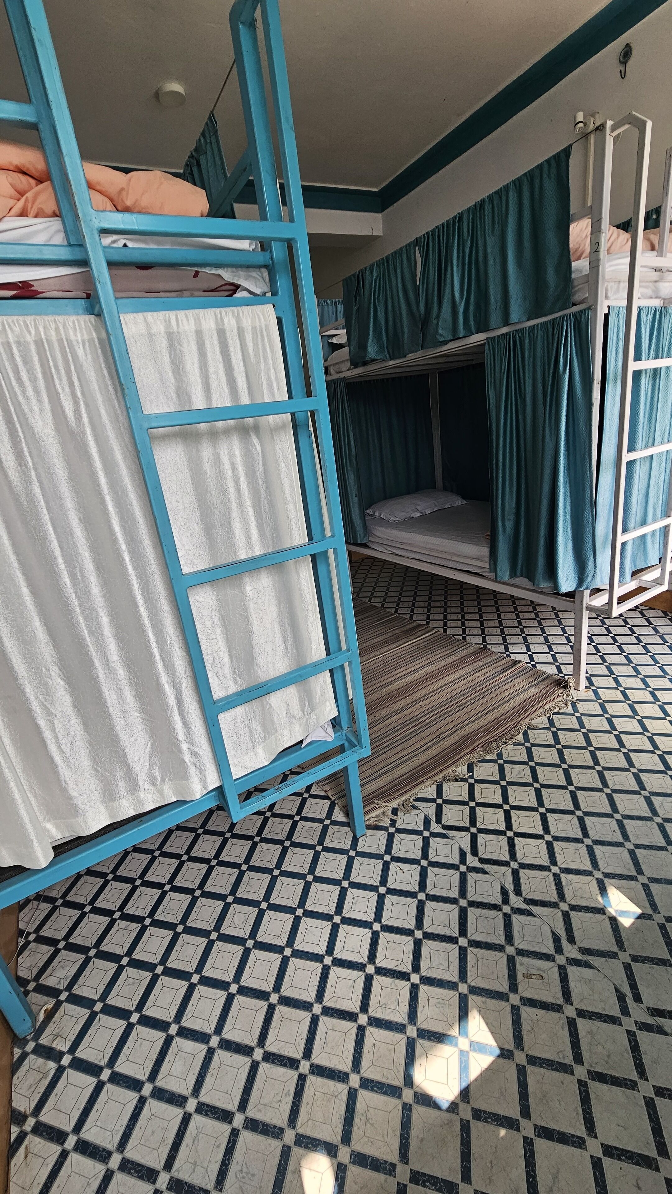 Un dormitorio con literas, una escalera y un suelo estampado.