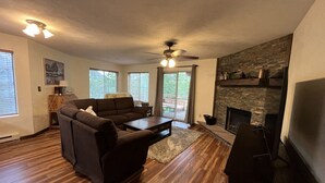 Ein Wohnzimmer mit Kamin, einer Couch, einem Couchtisch und einem Fernseher.