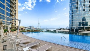 A rooftop infinity pool with lounge chairs, a view of the city skyline, and a clear sky. - Vogue | 52|42 Marina near Ain Dubai | JBR Beach (Dubai)