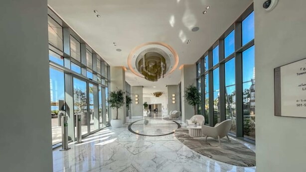 A spacious lobby with a marble floor, large windows, and modern furniture. - Vogue | 52|42 Marina near Ain Dubai | JBR Beach (Dubai)