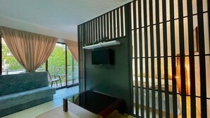 A modern living room with a sofa, a coffee table, and a TV mounted on the wall. - Apartments TP 777 (Budva)