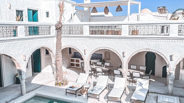 Una piscina al aire libre, sombrillas, sillones reclinables de piscina