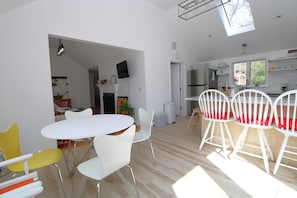 A modern kitchen with white cabinets, a built-in oven, and a window overlooking the garden.