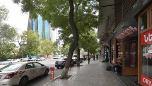 A city street with a taxi, parked cars, and pedestrians. - Stay Inn on Lusavorich 3 (Yerevan)