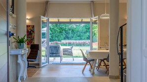 A spacious room with a large sliding glass door leading to a patio with outdoor seating.