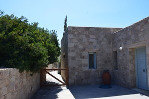 A stone building with a door, a window, and a gate.