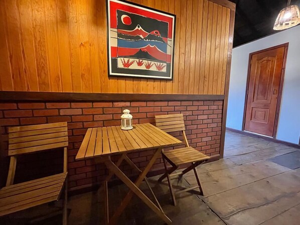 A wooden wall with a mural, a brick wall, and a wooden door. - Casa El Patio - Rustic studio (Las Poyatas)