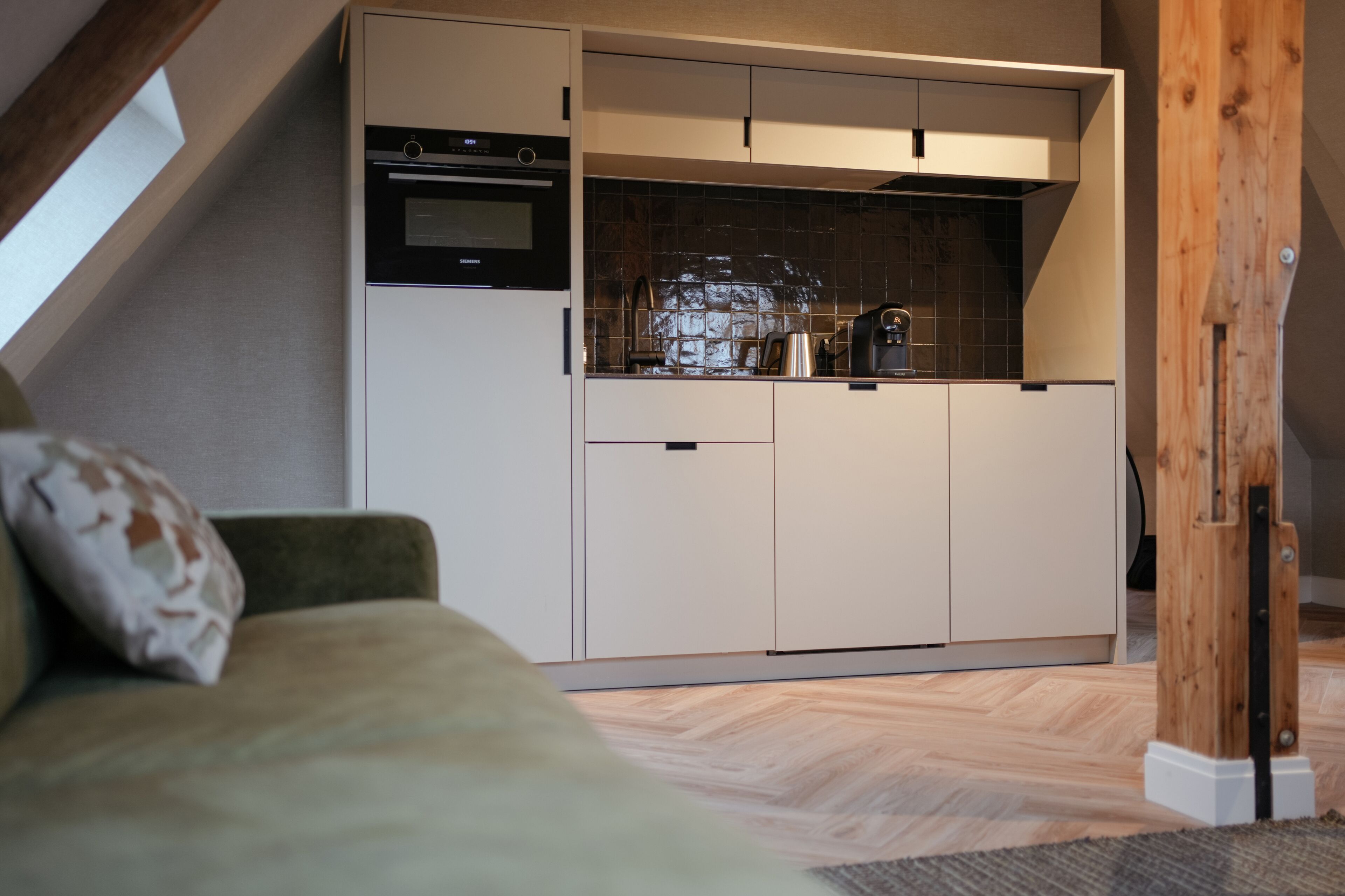 A compact kitchen with built-in appliances, a dining area, and a cozy seating space.