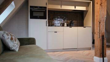 A compact kitchen with built-in appliances, a dining area, and a cozy seating space.