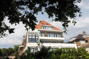 Una casa moderna de dos pisos con ventanas grandes y techo inclinado.