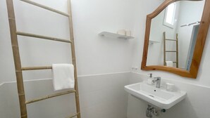 A bathroom with a wooden ladder, a sink with a mirror, and a toilet paper holder on the wall. - Eden Gomera Suite (Lepe)