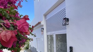 A white building with a glass door and a small porch. - Eden Gomera Suites - Rooftop terrace 2Br apartment with gorgeous oceanviews (Lepe)